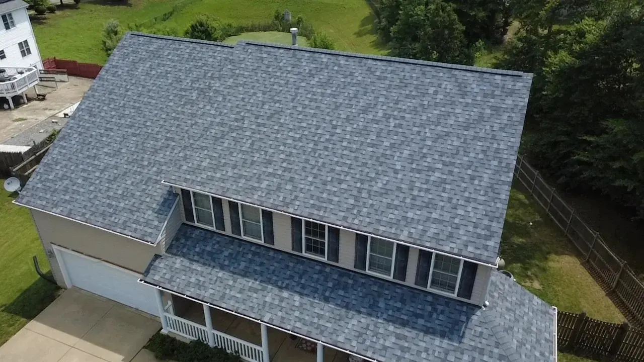 Aerial view of a completed gray shingle roof on a two-story home